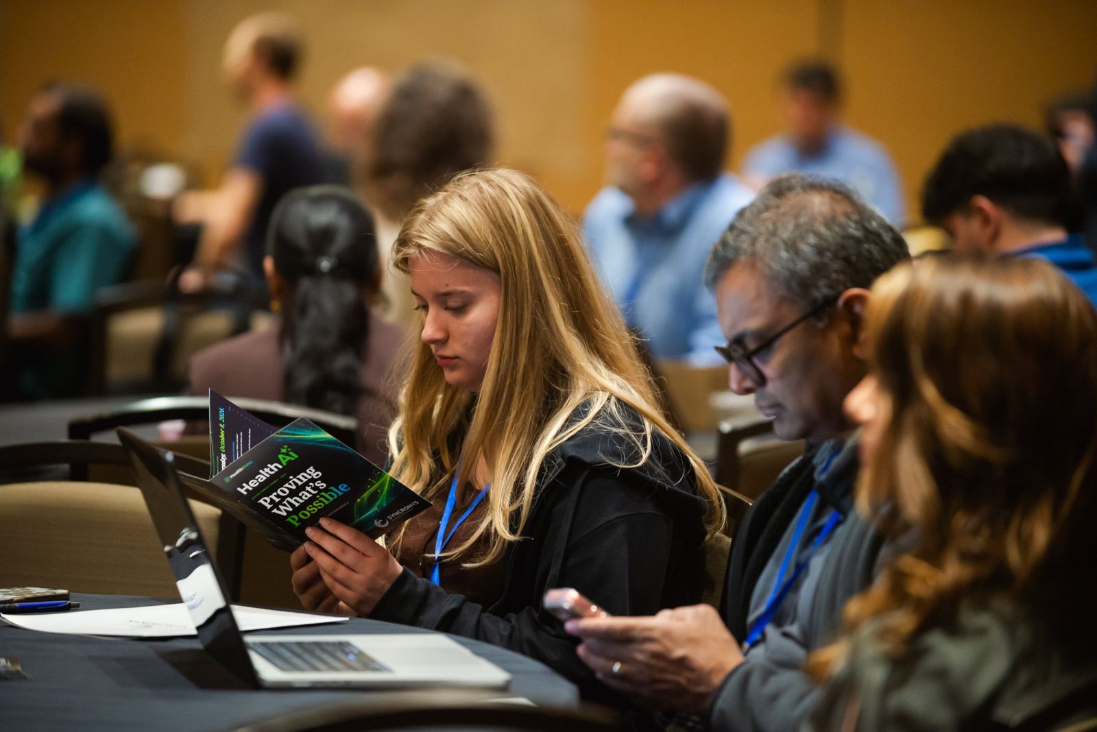 An attendee reading the HealthAI 2026 program booklet
