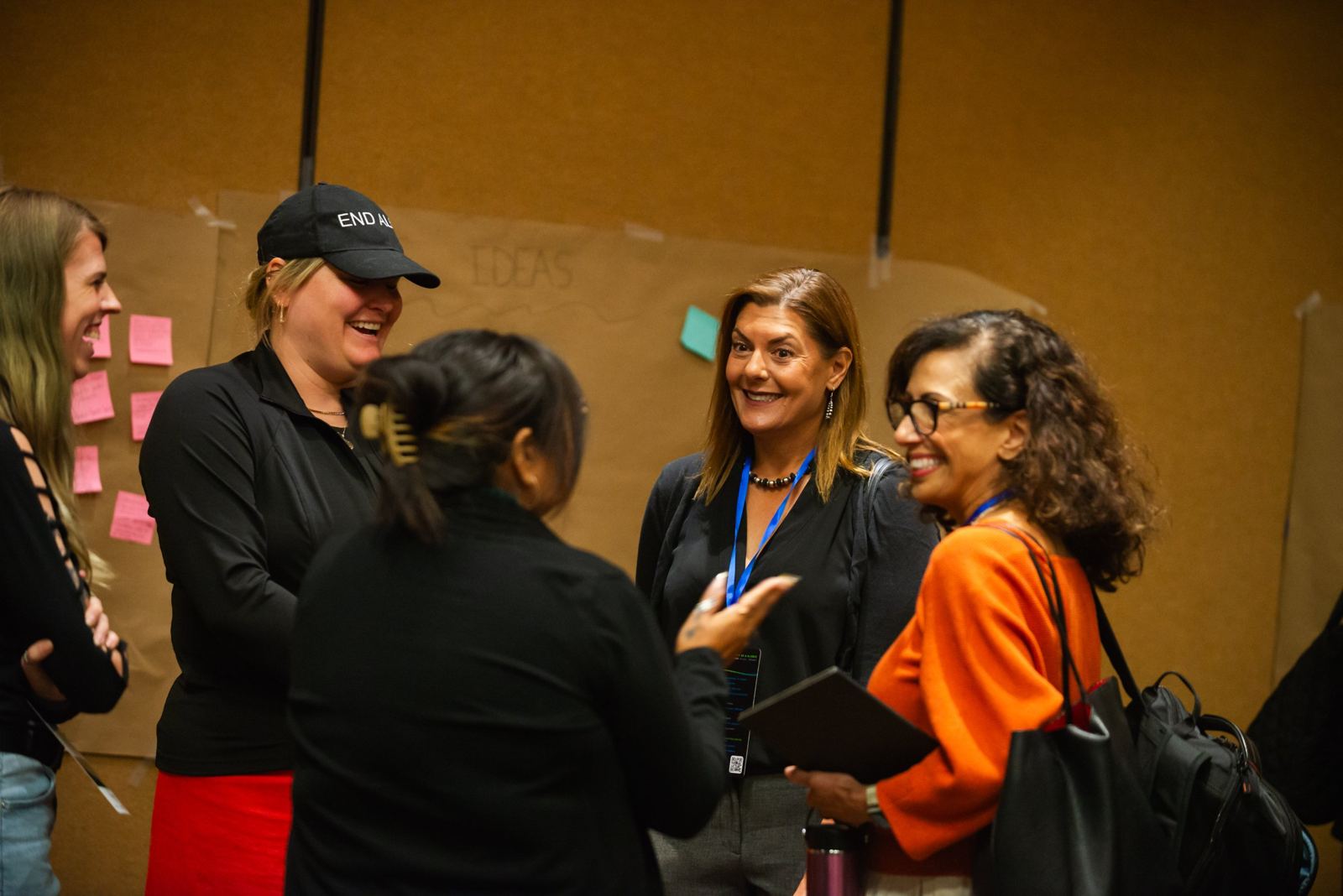 Attendees laughing together at the Big Ideas wall during a break