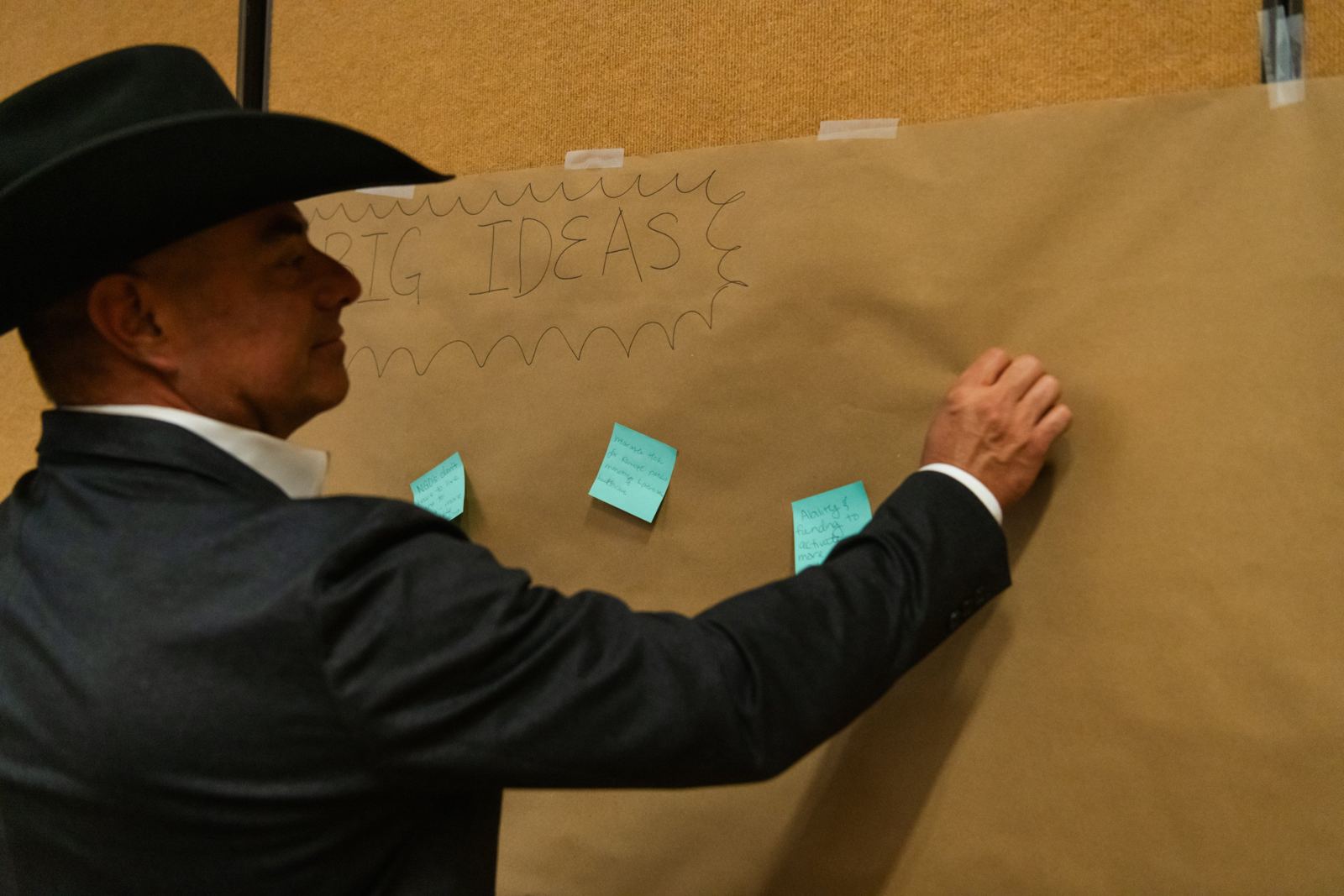 An attendee posting a note on the Big Ideas wall